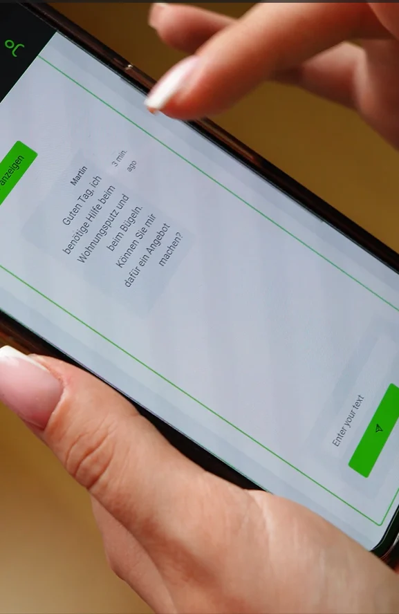 Close-up of hands holding a phone showing a milles chat about cleaning help.
